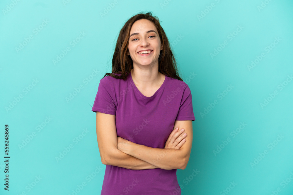 Obraz premium Young caucasian woman isolated on blue background keeping the arms crossed in frontal position