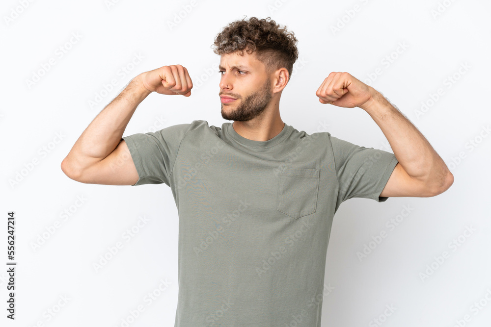 Young caucasian handsome man isolated on white background doing strong gesture Young caucasian handsome man isolated on white background doing strong gesture