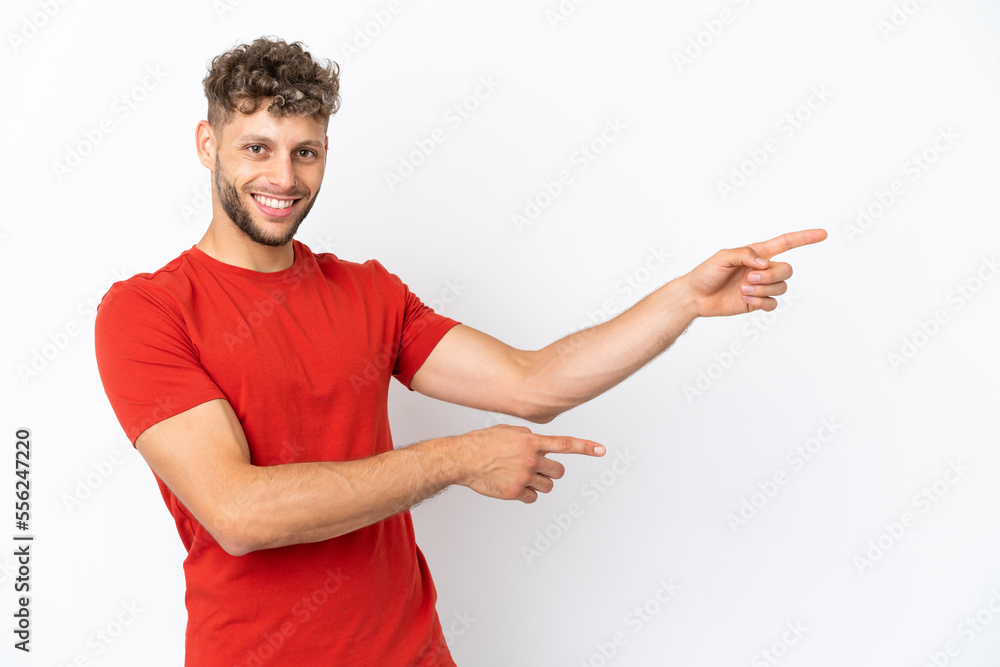 Young caucasian handsome man isolated on white background pointing finger to the side and presenting a product Young caucasian handsome man isolated on white background pointing finger to the side and presenting a product