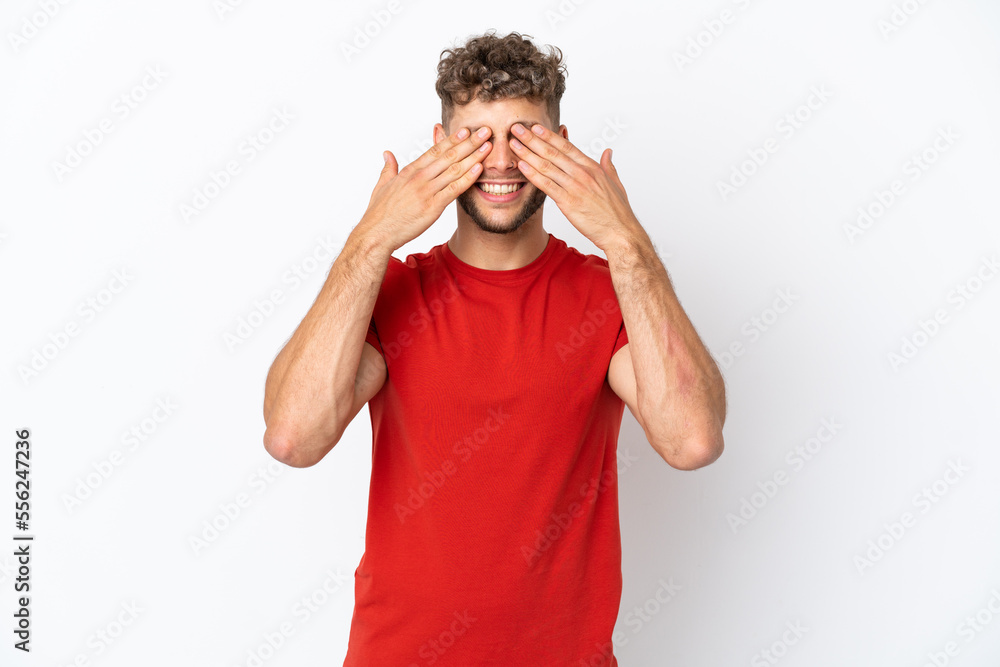Young caucasian handsome man isolated on white background covering eyes by hands and smiling Young caucasian handsome man isolated on white background covering eyes by hands and smiling
