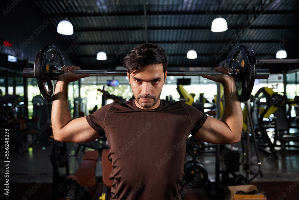 young athletic man exercising with barbell in the gym young athletic man exercising with barbell in the gym