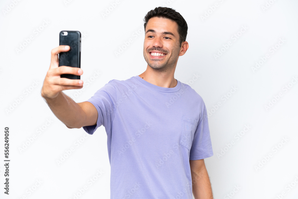 Young handsome man over isolated white background making a selfie with mobile phone Young handsome man over isolated white background making a selfie with mobile phone
