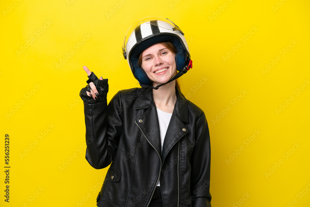 Fototapeta premium Young English woman with a motorcycle helmet isolated on yellow background showing and lifting a finger in sign of the best