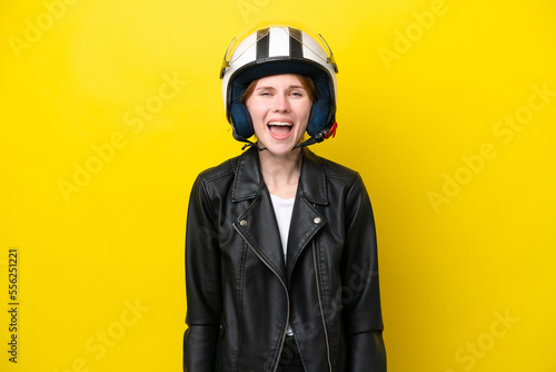 Young English woman with a motorcycle helmet isolated on yellow background with surprise facial expression