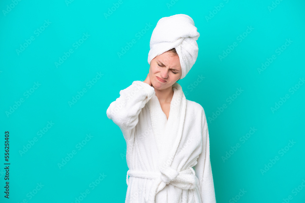 Young woman in a bathrobe isolated on blue background with neckache Young woman in a bathrobe isolated on blue background with neckache