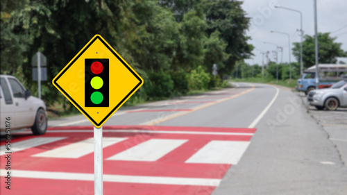 Yellow warn sign to beware of traffic light on blur background 