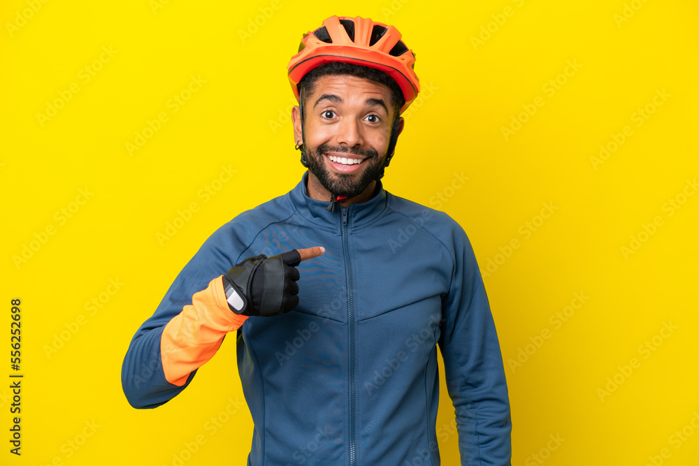 Young cyclist Brazilian man isolated on yellow background with surprise facial expression Young cyclist Brazilian man isolated on yellow background with surprise facial expression