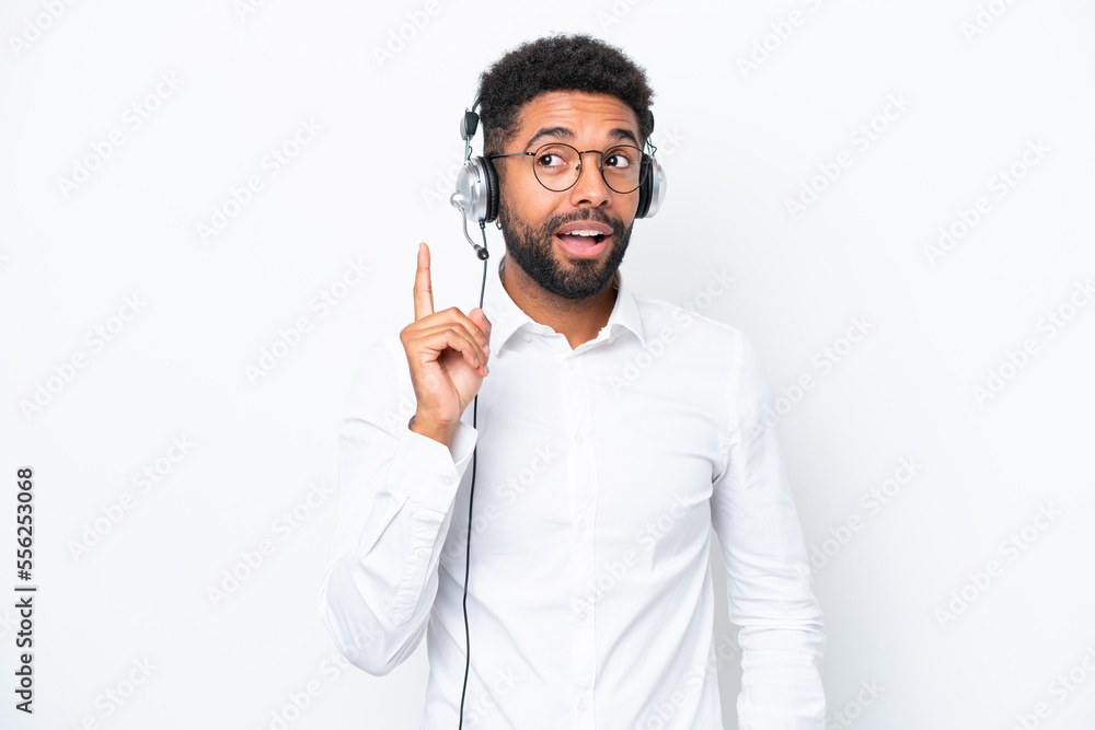Telemarketer Brazilian man working with a headset isolated on white background thinking an idea pointing the finger up Telemarketer Brazilian man working with a headset isolated on white background thinking an idea pointing the finger up