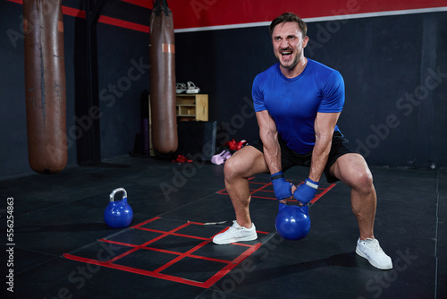 athletic man training with kettlebell in the gym