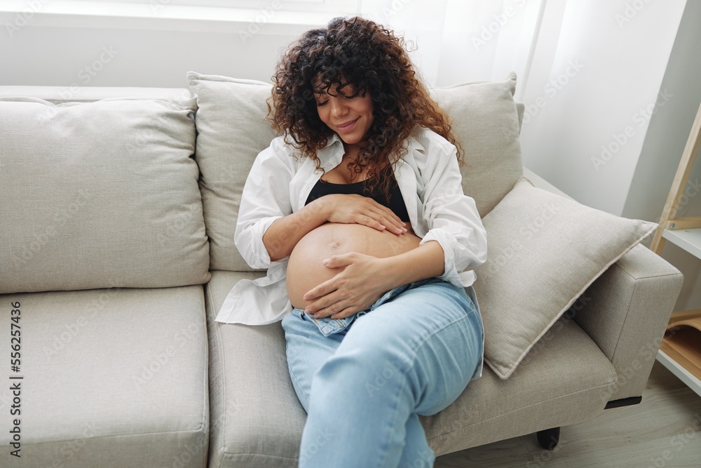 Pregnant woman smile and happiness lies on the couch freedom and strokes  her belly with a baby in the last month of pregnancy, mother's day  lifestyle Stock Photo | Adobe Stock