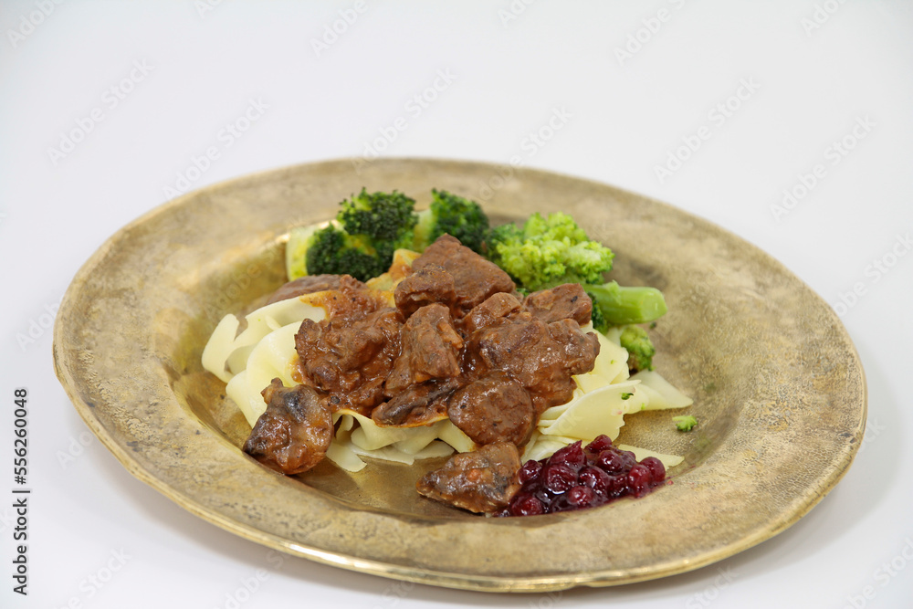  venison ragout with ribbon noodles and broccoli nobly served on a plate