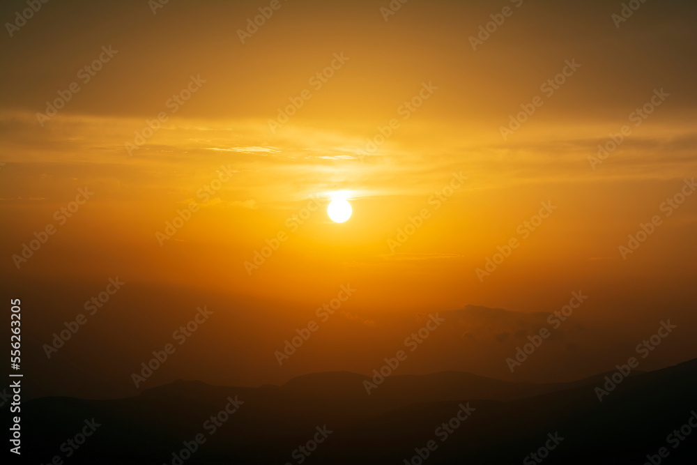 Dramatic colorful sunset sky with clouds over the mountains