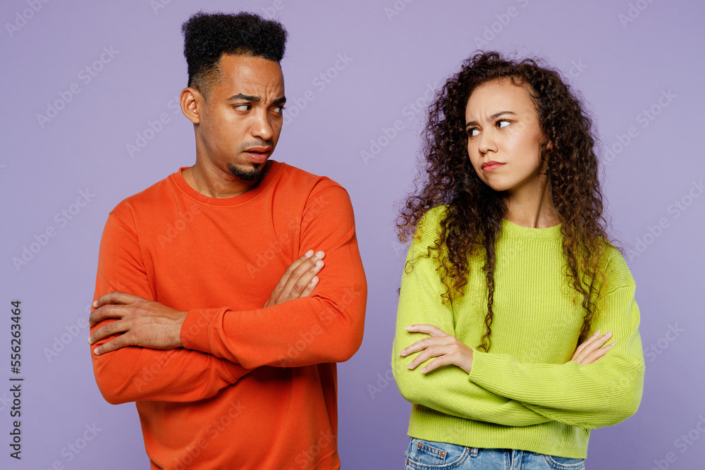 Obraz premium Young offended sad grumpy couple two friends family man woman of African American ethnicity wearing casual clothes together hold hands crossed folded isolated on pastel plain light purple background.