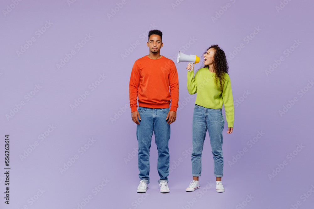 Full body young couple two friends family man woman of African American ethnicity wear casual clothes together hold scream in ear megaphone announces isolated on plain pastel light purple background. Full body young couple two friends family man woman of African American ethnicity wear casual clothes together hold scream in ear megaphone announces isolated on plain pastel light purple background.