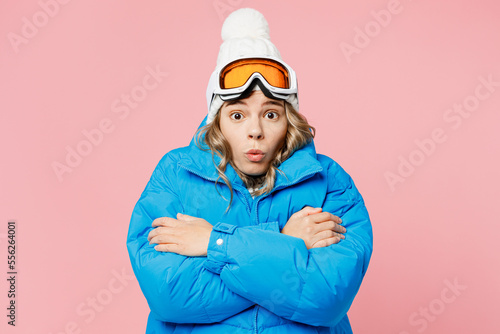 Snowboarder shocked sad woman wears blue suit goggles mask hat ski padded jacket hold herself warming isolated on plain pastel pink background. Winter extreme sport hobby weekend trip relax concept.