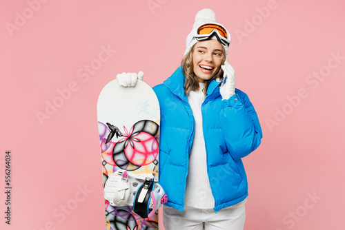Snowboarder smiling woman wear blue suit goggles mask hat ski padded jacket talk speak mobile cell phone isolated on plain pastel pink background Winter extreme sport hobby weekend trip relax concept