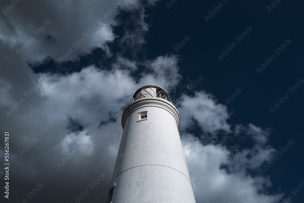 Impressive view of a working lighthouse on the Suffolk, UK coastline. Seen bright against a dark sky.
