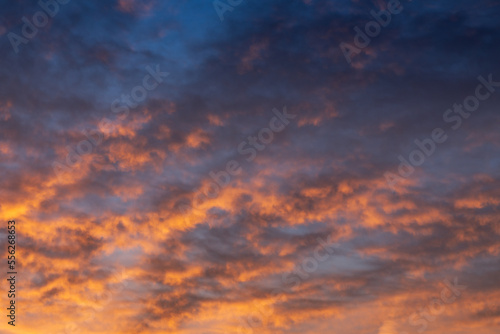 Picturesque colorful cloudscape background with light clouds in vivid sunset colors