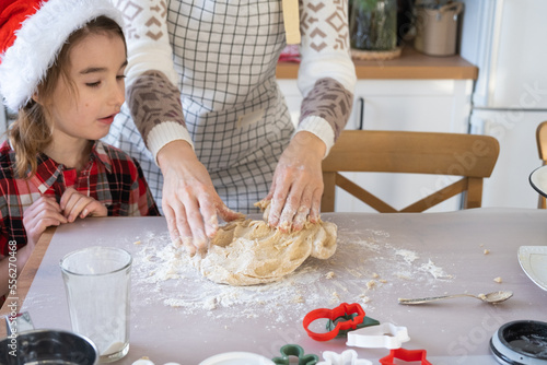 Mom and daughter in the white kitchen are preparing cookies for Christmas and new year. Family day  preparation for the holiday  learn to cook delicious pastries  cut shapes out of dough with molds