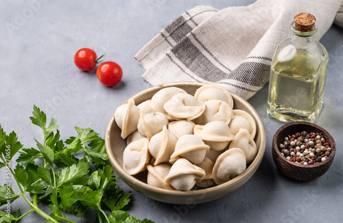 Dumplings with meat. The Russian traditional dish is Siberian pelmeni. Served with fresh herbs, butter and vegetables