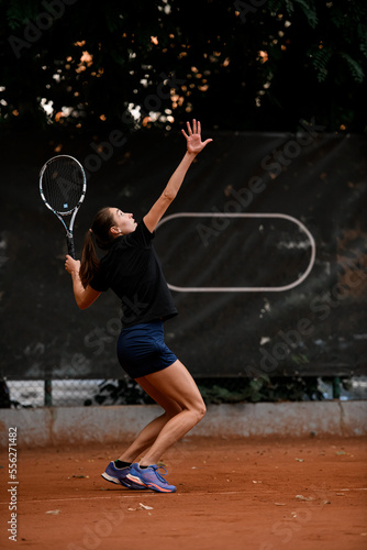 view of active sporty woman tennis player with tennis racket in hand doing pitch