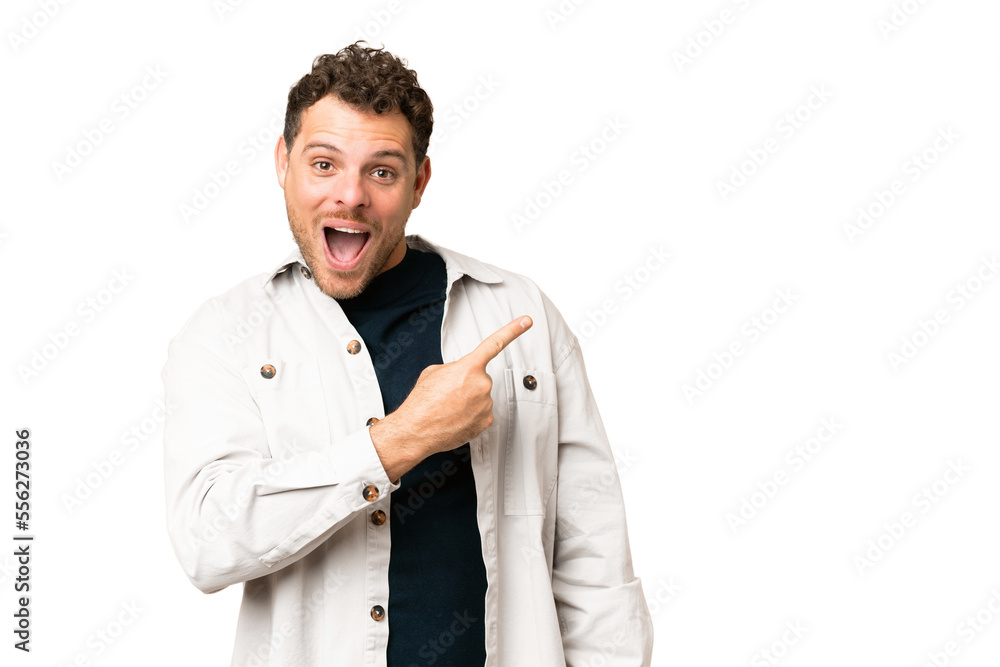 Brazilian man over isolated chroma key background surprised and pointing side Brazilian man over isolated chroma key background surprised and pointing side