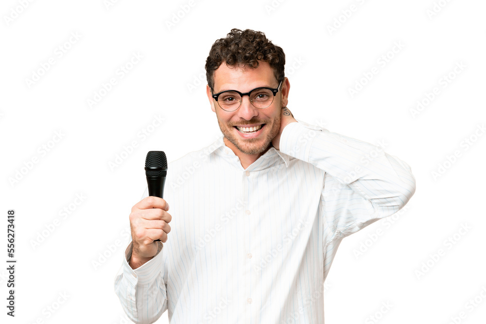 Brazilian man picking up a microphone over isolated chroma key background laughing Brazilian man picking up a microphone over isolated chroma key background laughing
