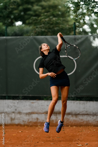 view on confident energy female tennis player with racket ready to hit a tennis ball.