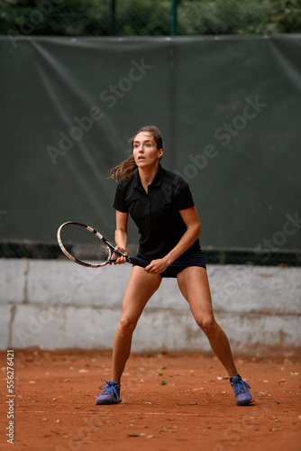 Beautiful energy female tennis player with racket ready to hit tennis ball. © fesenko