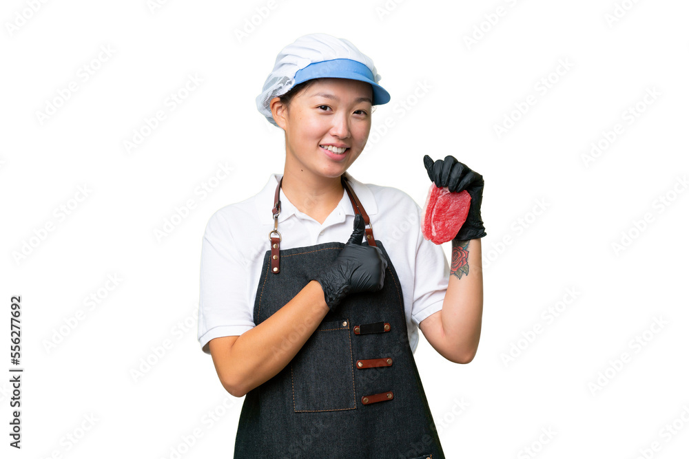 Young caucasian woman wearing an apron and serving fresh cut meat over isolated background giving a thumbs up gesture Young caucasian woman wearing an apron and serving fresh cut meat over isolated background giving a thumbs up gesture