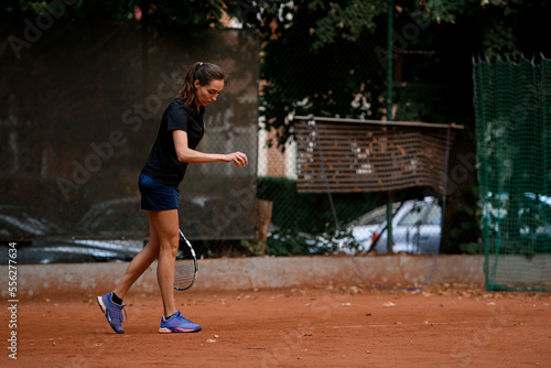 professional female tennis player holding ball and racket preparing to serve at beginning of game © fesenko