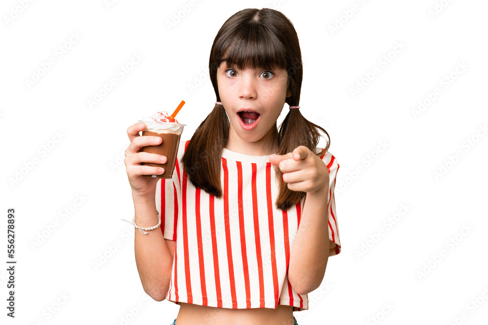 Young man with chocolat milkshake over isolated background surprised and pointing front Young man with chocolat milkshake over isolated background surprised and pointing front