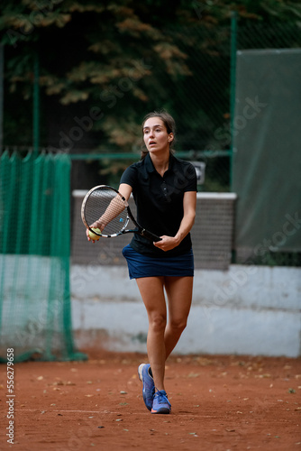 pretty female tennis player with racket and ball prepares to serve at beginning of game © fesenko