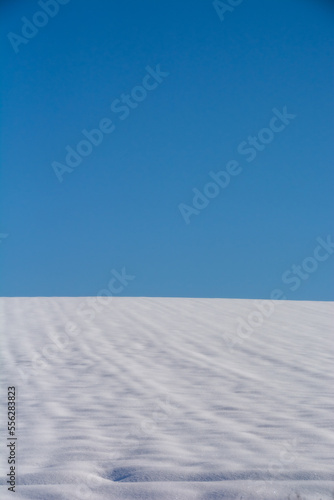 青空と雪が積もった冬の畑 