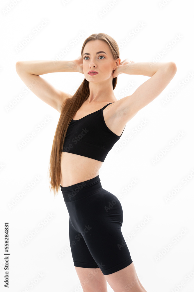 Slim sporty fitness young woman gymnast in sportswear training performs exercises on a white background Slim sporty fitness young woman gymnast in sportswear training performs exercises on a white background