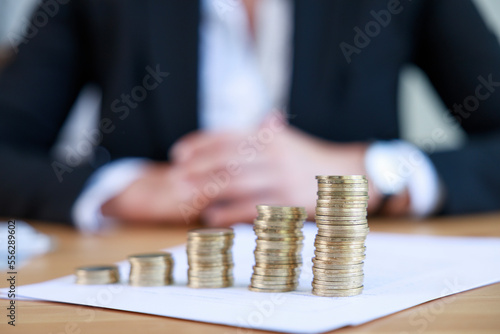 Mortgage loan application and savings plan concept. Businesswoman with coin stack on office desk.