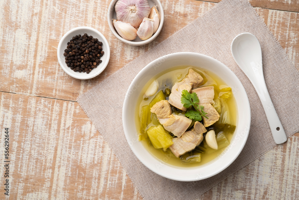Preserved mustard green with pork belly soup in white bowl.Top view Preserved mustard green with pork belly soup in white bowl.Top view