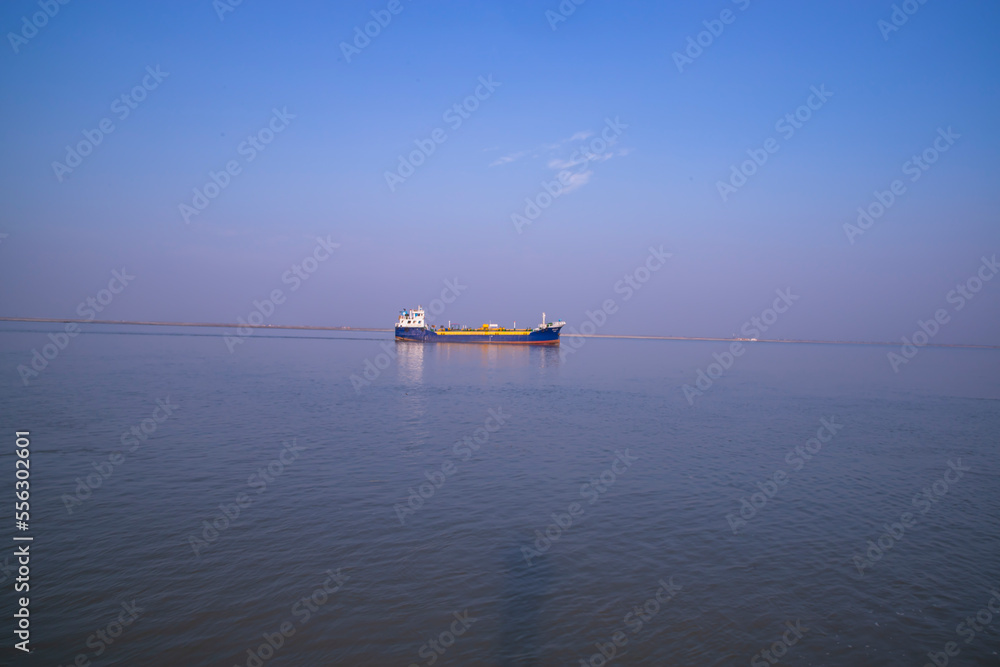 Landscape View of a small cargo ship against a blue sky on the  Padma river Bangladesh