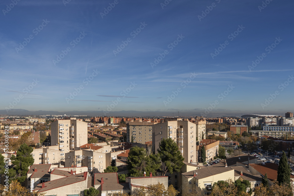 Views of building facades and roofs of the city on a sunny winter day with the mountains in the background