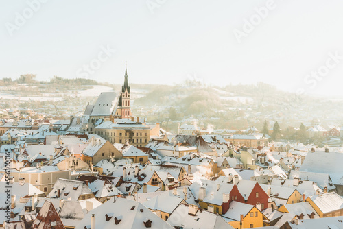 Český Krumlov, UNESCO. Historical town with Castle and Church at sunrise. Beautiful winter morning landscape with an illuminated monument. Snowy cityscape scene from the Cesky Krumlov, Czech Republic