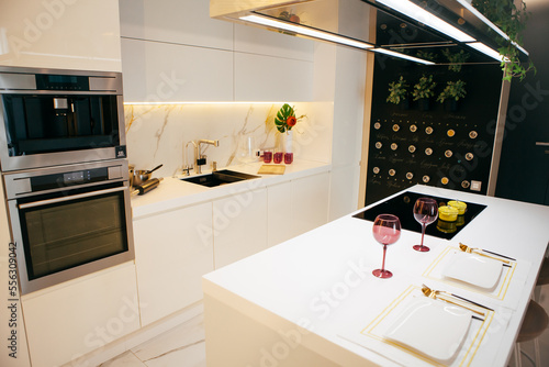 Modern kitchen interior with two plates and glasses on the table photo