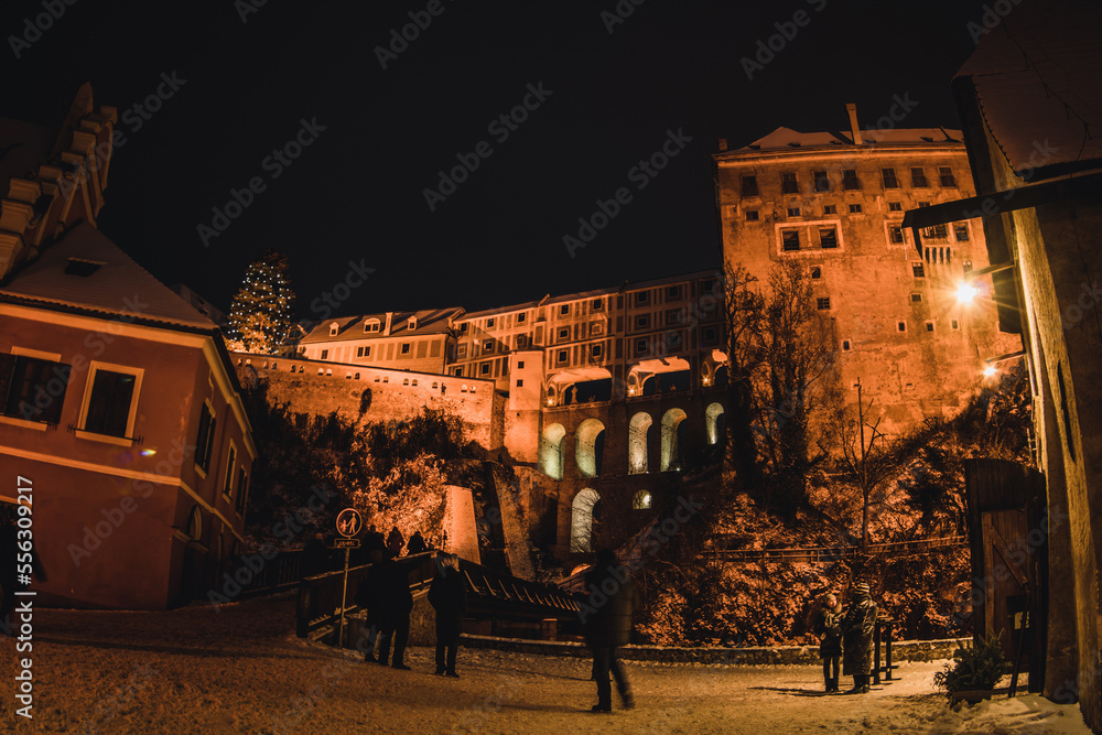 Český Krumlov, UNESCO. Historical town with Castle and Church at night. Beautiful winter night landscape with an illuminated monument. Snowy cityscape scene from the Cesky Krumlov, Czech Republic