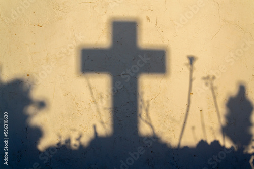 Shadow of a cross on a grave in a Greek cemetery at dawn