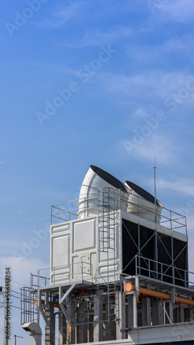 Cooling towers in data center building. Air conditioning cooling towers in front of building with fins to the front. Industrial cooling towers or air cooled water chillers with piping system.