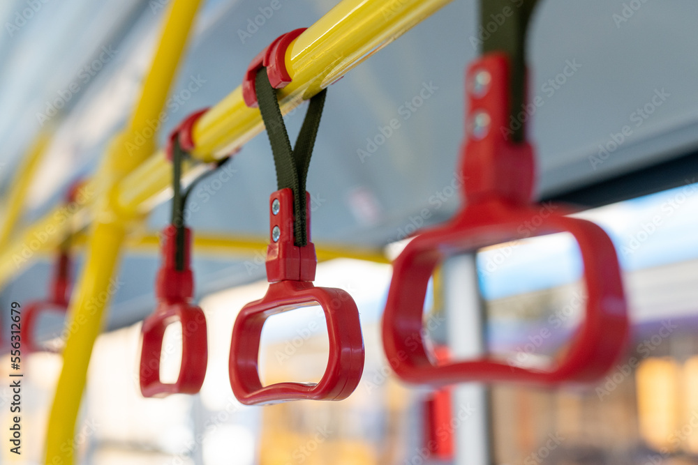 Handle on the bus. Red plastic handrail close-up. Handrails in public transport close-up. 