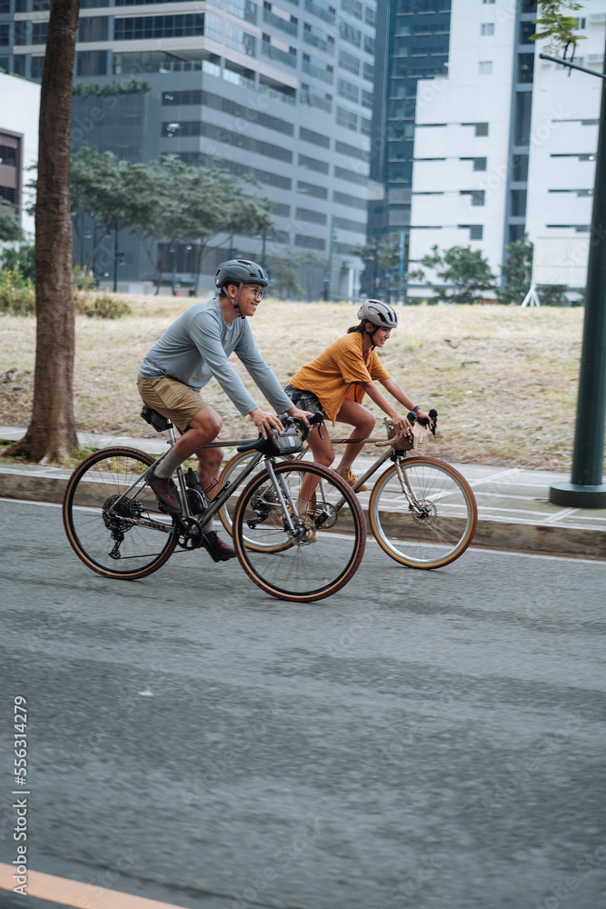 Obraz premium A young couple riding their bikes together in the city.