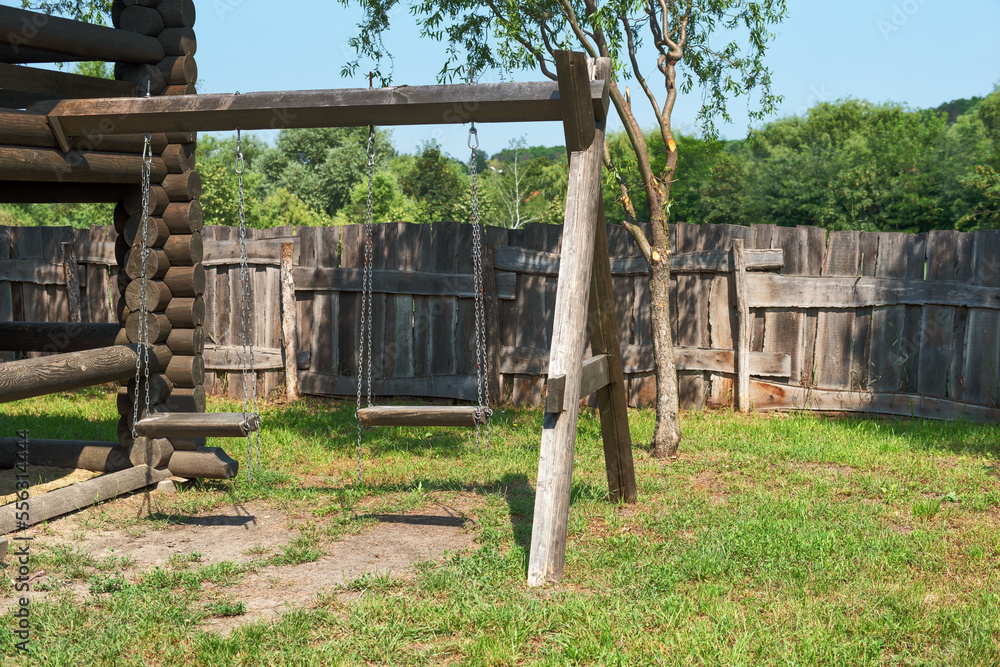 Old wooden swing, wooden playground, two swings Old wooden swing, wooden playground, two swings