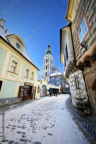 Český Krumlov, UNESCO. Historical town with Castle and Church at sunrise. Beautiful winter morning landscape with an illuminated monument. Snowy cityscape scene from the Cesky Krumlov, Czech Republic