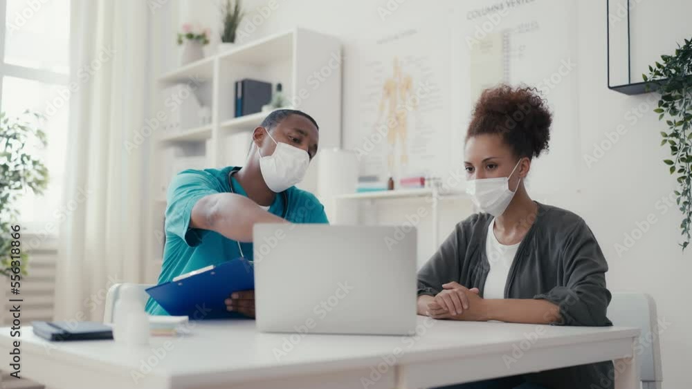Woman in mask visiting doctor's office, physician consultation amid pandemic Woman in mask visiting doctor's office, physician consultation amid pandemic