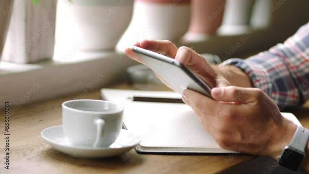 Man, tablet and hands working on coffee shop for morning planning, freelance work or remote work. Startup entrepreneur, company mobile app and designer working on digital tech device with tea in cafe Man, tablet and hands working on coffee shop for morning planning, freelance work or remote work. Startup entrepreneur, company mobile app and designer working on digital tech device with tea in cafe
